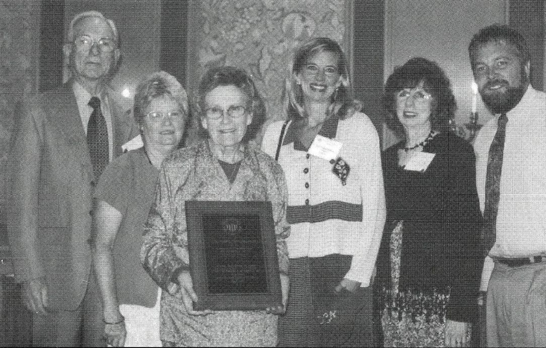 Norm Blam, Loretta Nemec, Maud Eastwood, Candi Brekhus and Tedi Fredrick standing together; Maud holds the award plaque